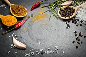 Spices and herbs over black stone background