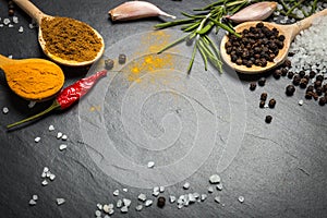 Spices and herbs over black stone background