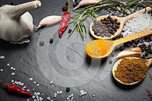 Spices and herbs over black stone background