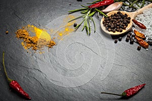 Spices and herbs over black stone background