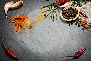 Spices and herbs over black stone background