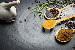 Spices and herbs over black stone background