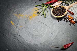 Spices and herbs over black stone background