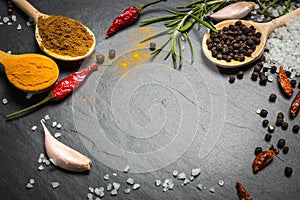 Spices and herbs over black stone background