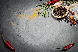 Spices and herbs over black stone background