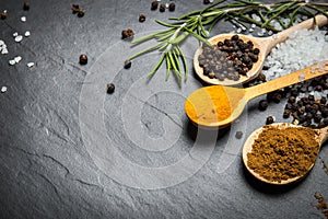 Spices and herbs over black stone background