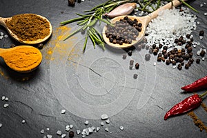 Spices and herbs over black stone background