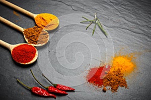 Spices and herbs over black stone background