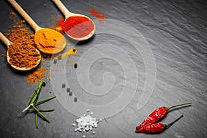 Spices and herbs over black stone background