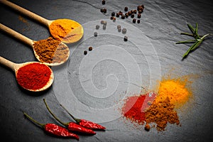 Spices and herbs over black stone background