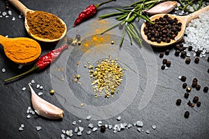 Spices and herbs over black stone background