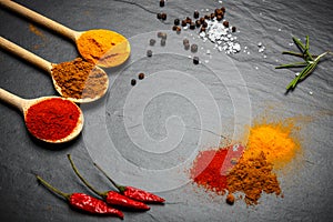 Spices and herbs over black stone background