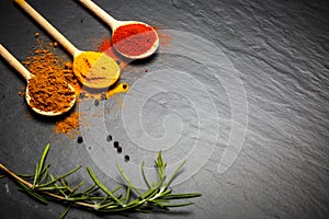 Spices and herbs over black stone background