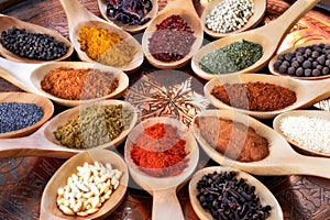 Spices and herbs in wooden spoons.