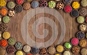 Spices and herbs on wooden table background. Frame of colorful seasonings, top view