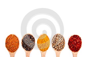 Spices mix on wooden spoons on a white wooden background. Top view