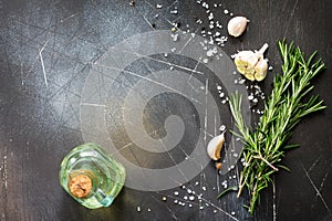 Spices, olive oil and herbs on a dark stone or slate table. Ingredients for cooking. Food background.
