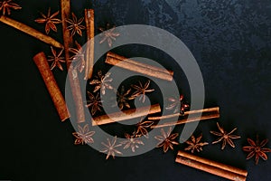 Spices sticks cinnamon and star anise on the old table. Rustic dark background, aroma close-up, macro