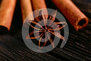 Spices sticks cinnamon and star anise on the old table. Rustic dark background, aroma close-up, macro