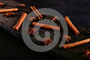 Spices sticks cinnamon and star anise on the old table. Rustic dark background, aroma close-up, macro