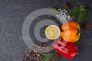 Spices on the stone black background. Condiments on a dark table