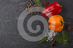 Spices on the stone black background. Condiments on a dark table