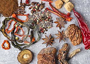 Spices on the stone black background. Condiments on a dark table