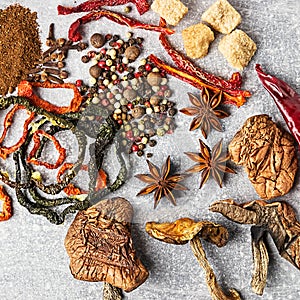 Spices on the stone black background. Condiments on a dark table