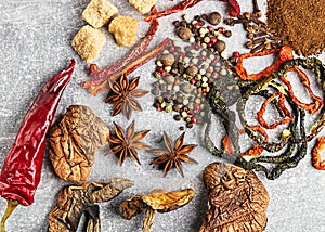 Spices on the stone black background. Condiments on a dark table