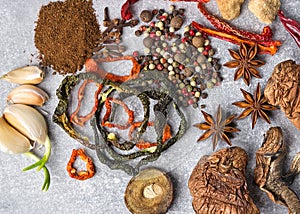 Spices on the stone black background. Condiments on a dark table