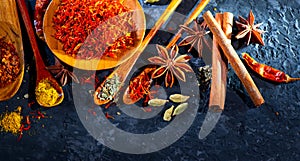 Spices. Various Indian spices on black stone table. Spice and herbs on slate background. Assortment of seasonings, condiments