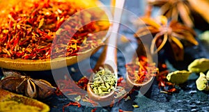 Spices. Various Indian spices on black stone table. Spice and herbs on slate background. Cooking