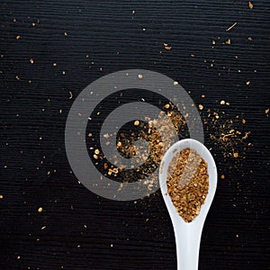 Spices were scattered on black wooden table. Measuring spoon. Cooking and seasoning for taste