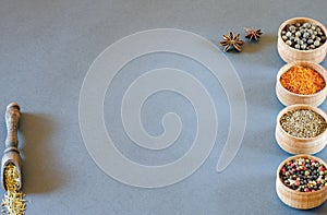 Spices in wooden bowls on a gray background