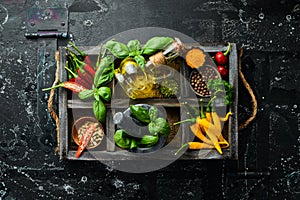 Spices in a wooden box: basil, pepper, oil, paprika, herbs. Food background.