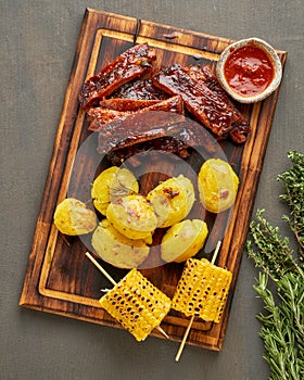 Spicy barbecue pork ribs, corn ears and crushed smashed potatoes. Slow cooking recipe