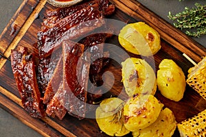 Spicy barbecue pork ribs, corn ears and crushed smashed potatoes. Slow cooking recipe