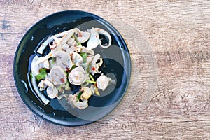 Spicy boiled pork innards with herb Thai salad on plate