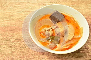 Spicy boiled slice pickled bamboo shoot with chicken and blood in coconut milk curry soup on bowl