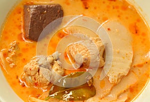 Spicy boiled slice pickled bamboo shoot with chicken and blood in coconut milk curry soup on bowl