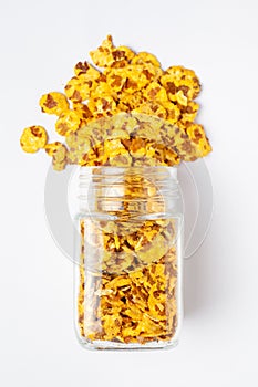 Spicy Chana Jor Garam spilled out and in a glass jar, made with air-fried Bengal Chickpea.