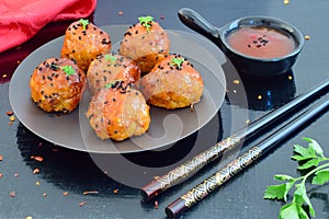 Spicy chicken balls in sweet chilli glaze on a metal tray