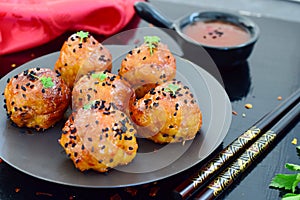 Spicy chicken balls in sweet chilli glaze on a metal tray