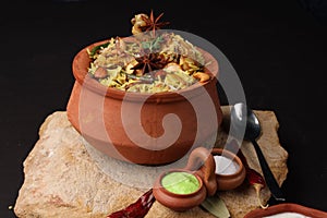 Spicy chicken biryani in traditional handi or clay pot.