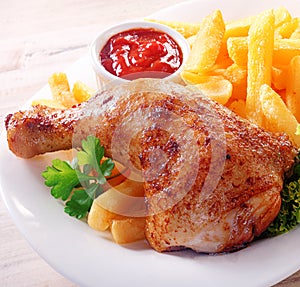Spicy chicken drumstick with French fries photo