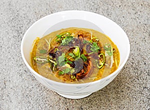 Spicy chicken haleem with fried onion served in dish isolated on background top view of indian spices and pakistani food