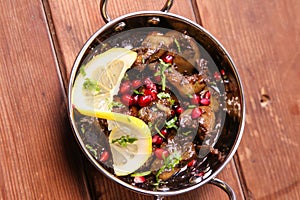 Spicy Chicken Liver with lime and pomegranate seeds served in dish isolated on background top view of hot mezza photo