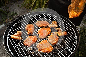 Spicy chicken wings and steaks on grill