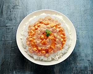 Spicy chickpeas curry with rice, tomato and Poppadoms in white plate. Healthy tasty vegetarian food