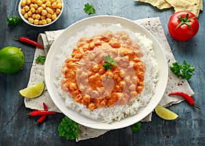 Spicy chickpeas curry with rice, tomato and Poppadoms in white plate. Healthy tasty vegetarian food